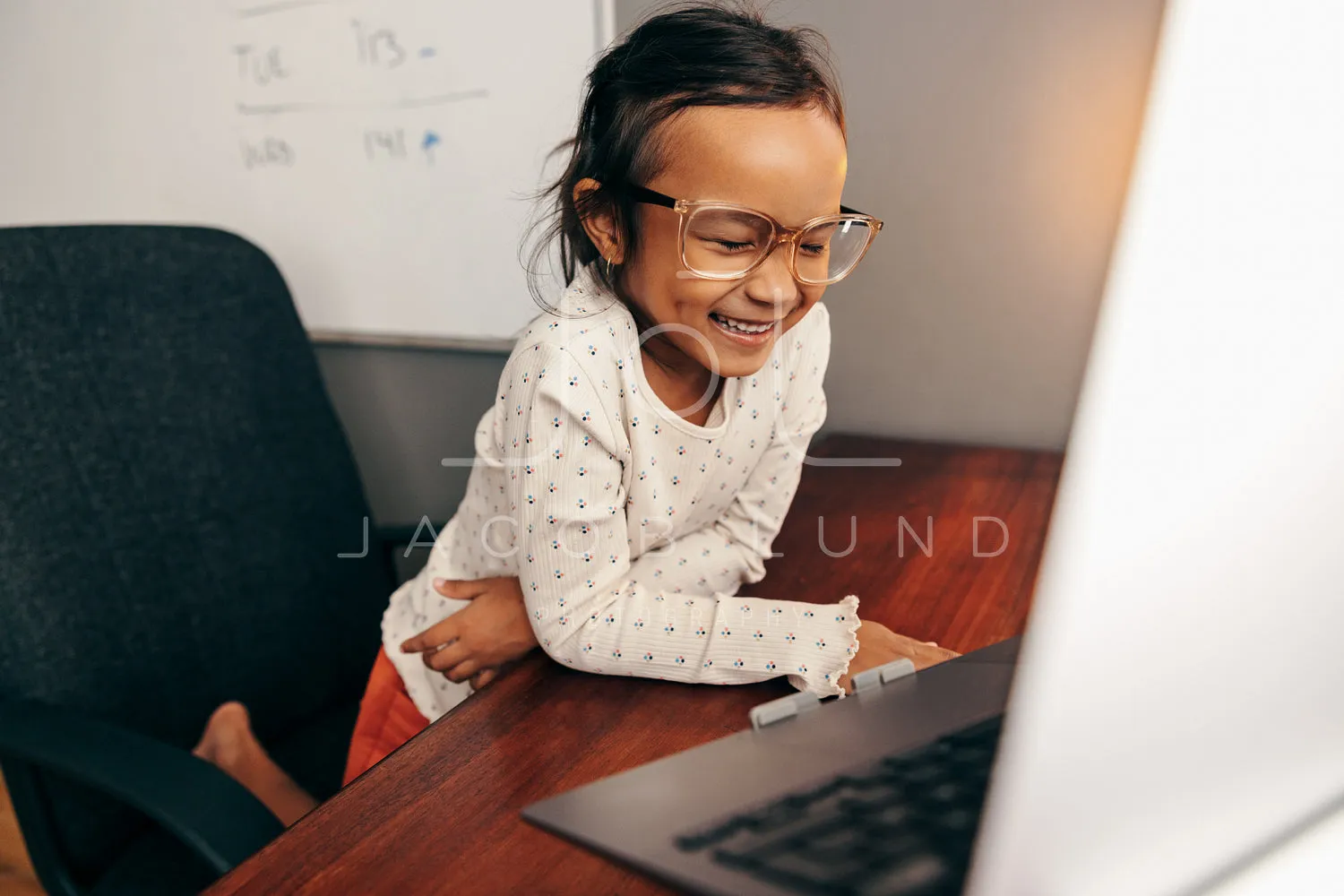 Cheerful little girl having fun in her mother's work desk